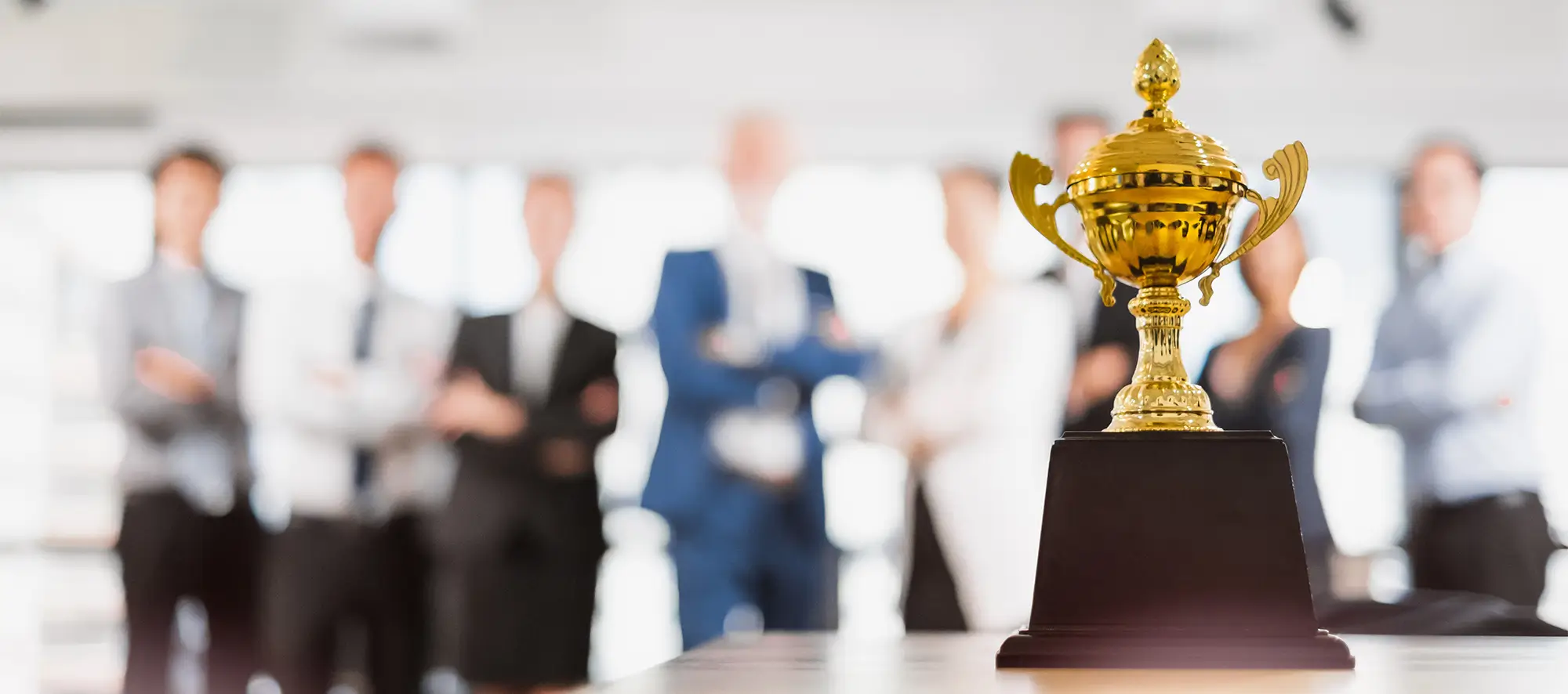 Trophy sitting on a table with employees in the background.
