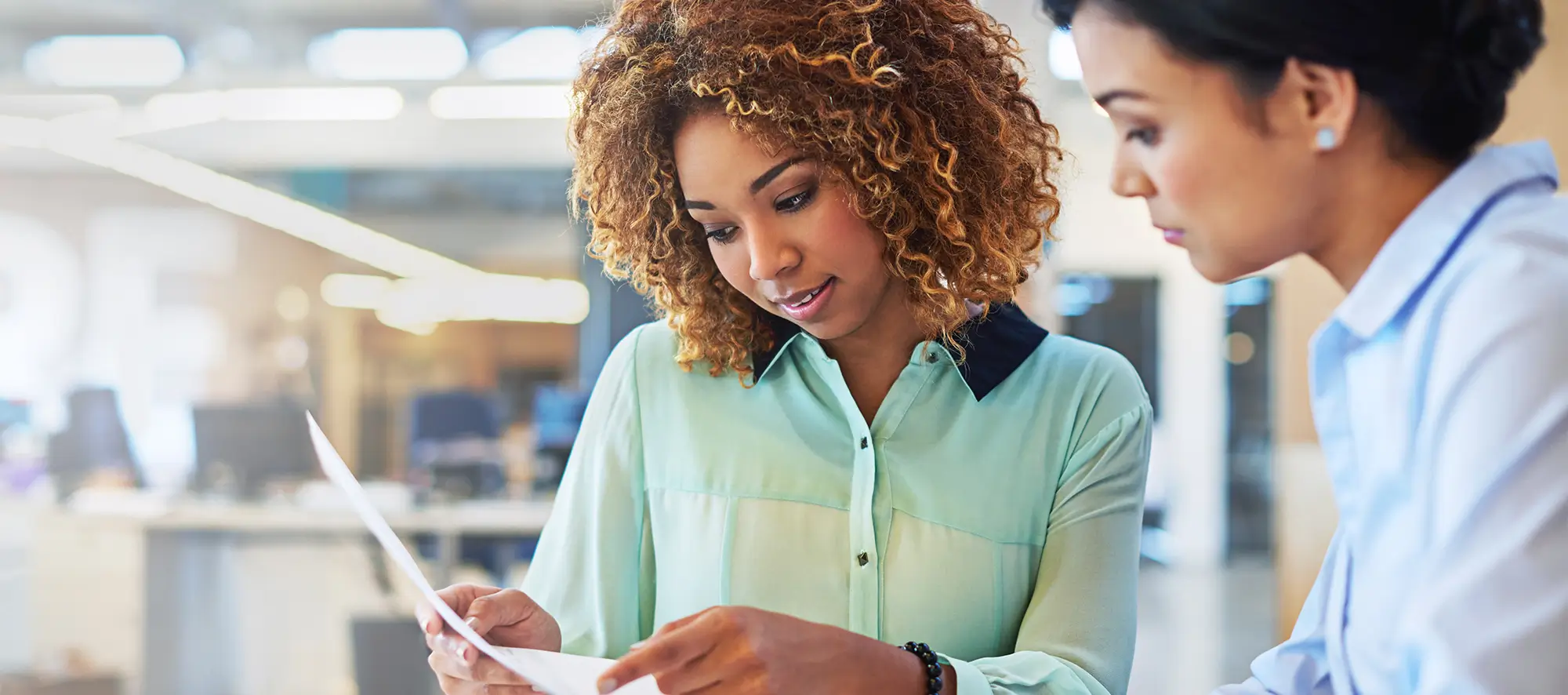 Two business women looking at paperwork.