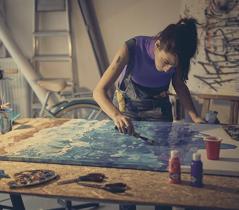 Visual artist painting on large canvas