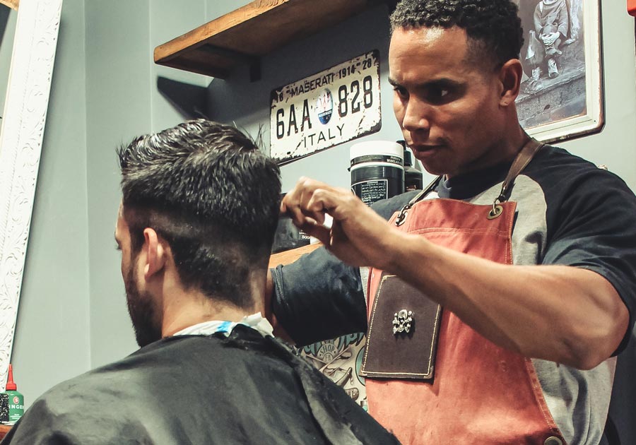 Man in chair getting his hair cut at a barber shop