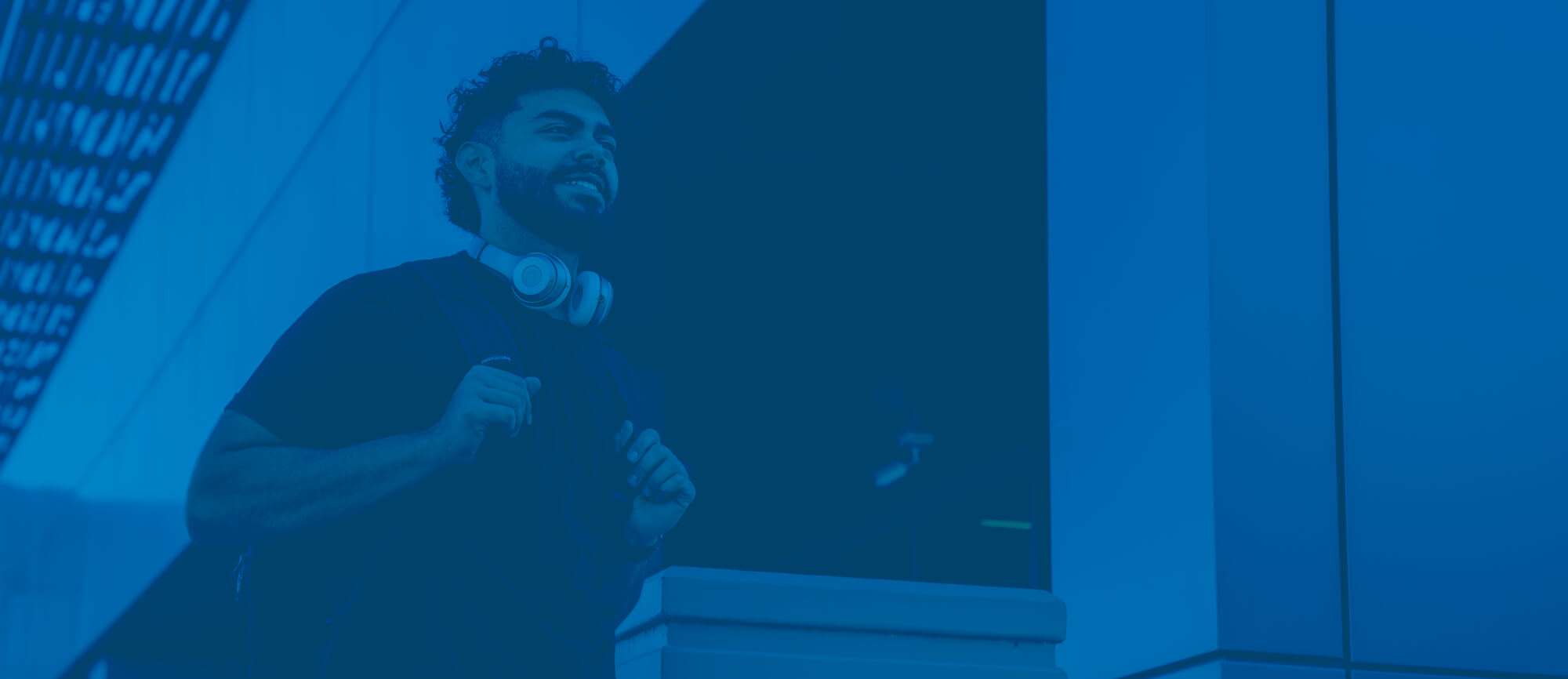 Graphically blue-toned image of a student outside with a backpack.