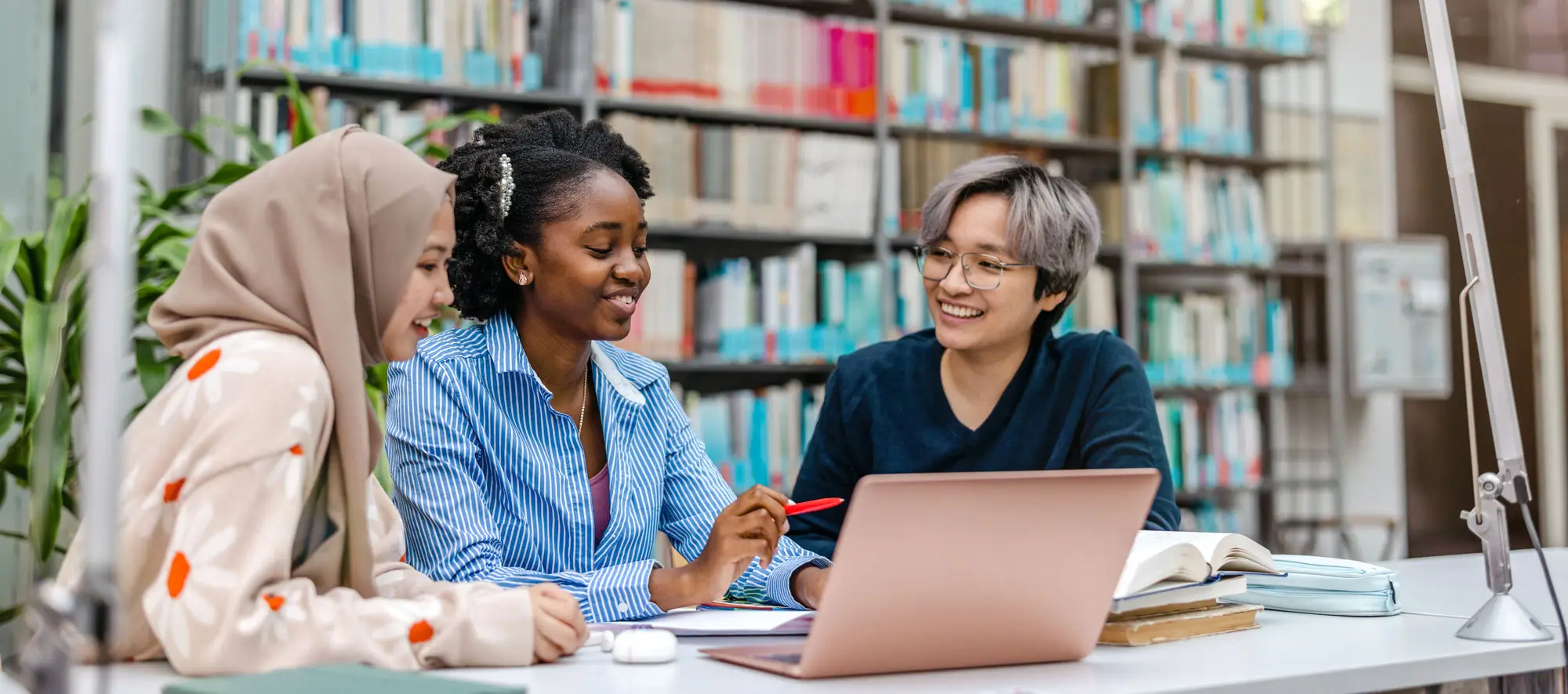 Multiethnic group of students sitting in a library and studying together