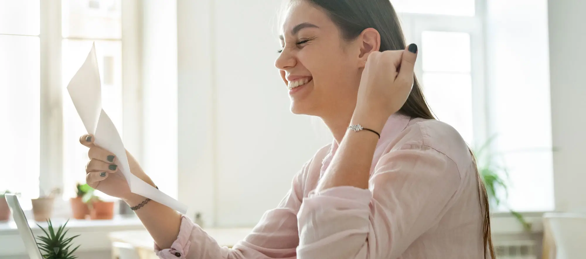 Happy female student excited reading grant letter