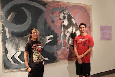 Two students in front of a painting.