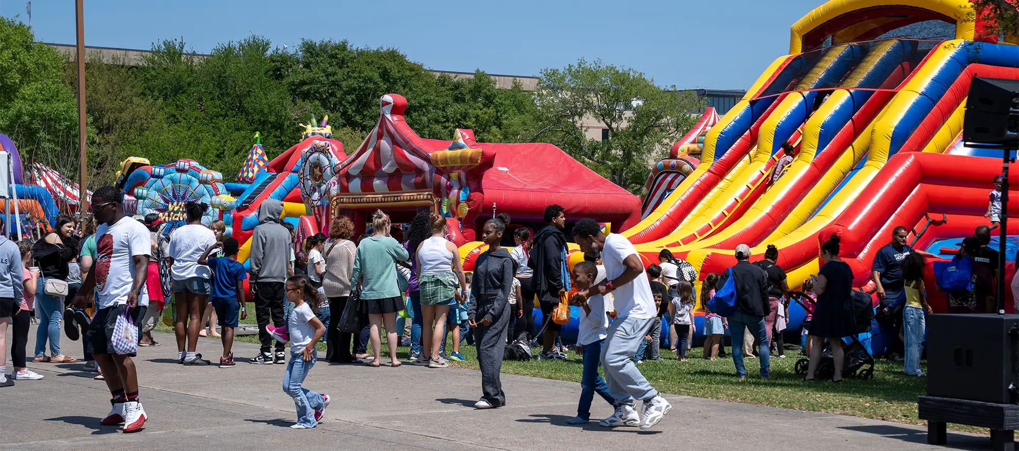 Community members enjoying COM event with bouncy houses.