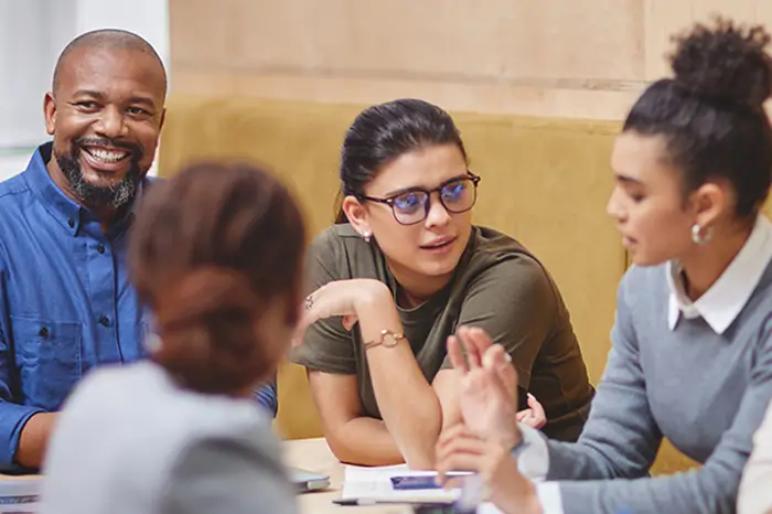 Faculty members talking at a conference table