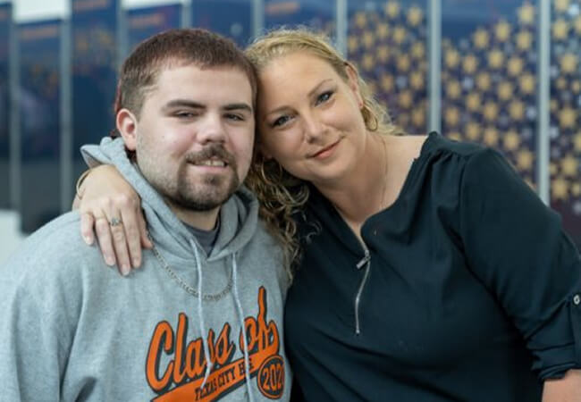 Portrait of a promise student with his mom outside.