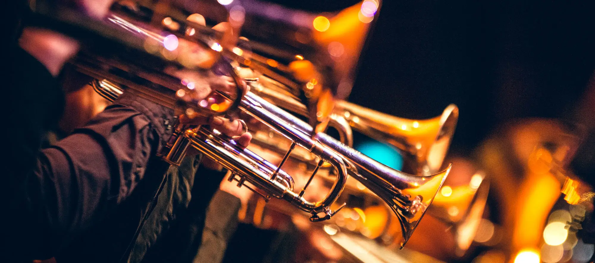Close-up photo of horn section in a jazz band performing.
