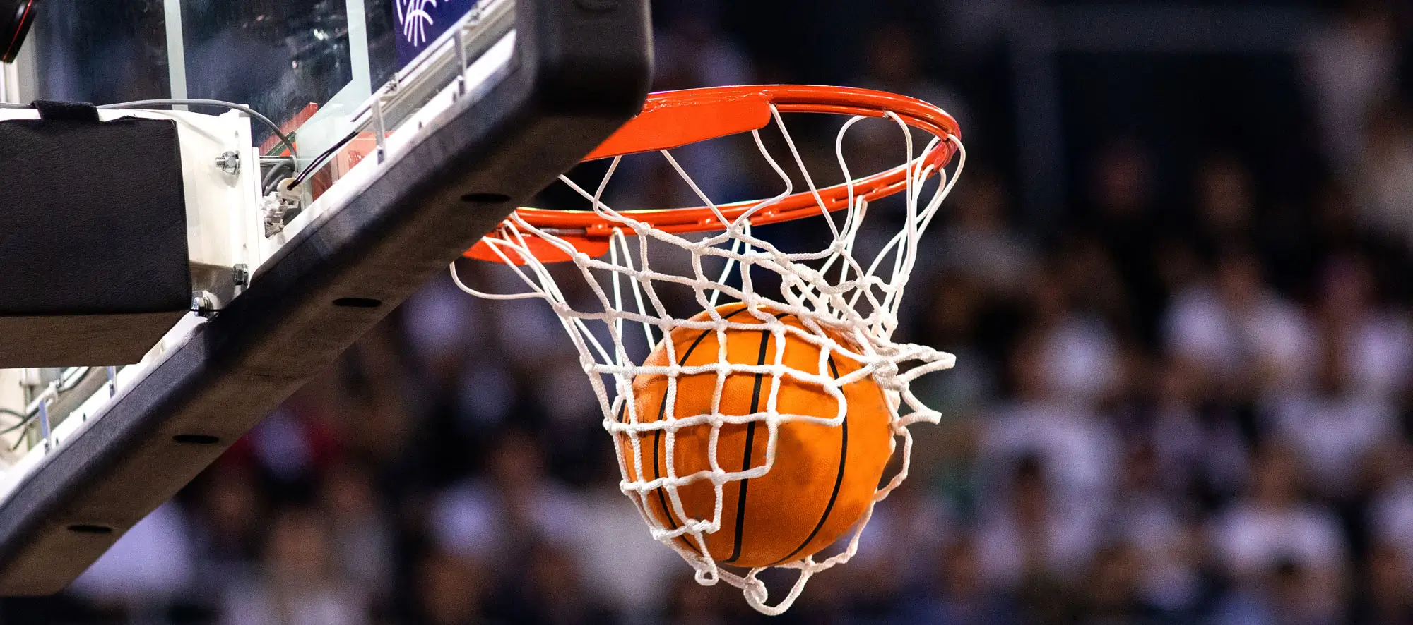 Closeup shot of a basketball going into hoop.