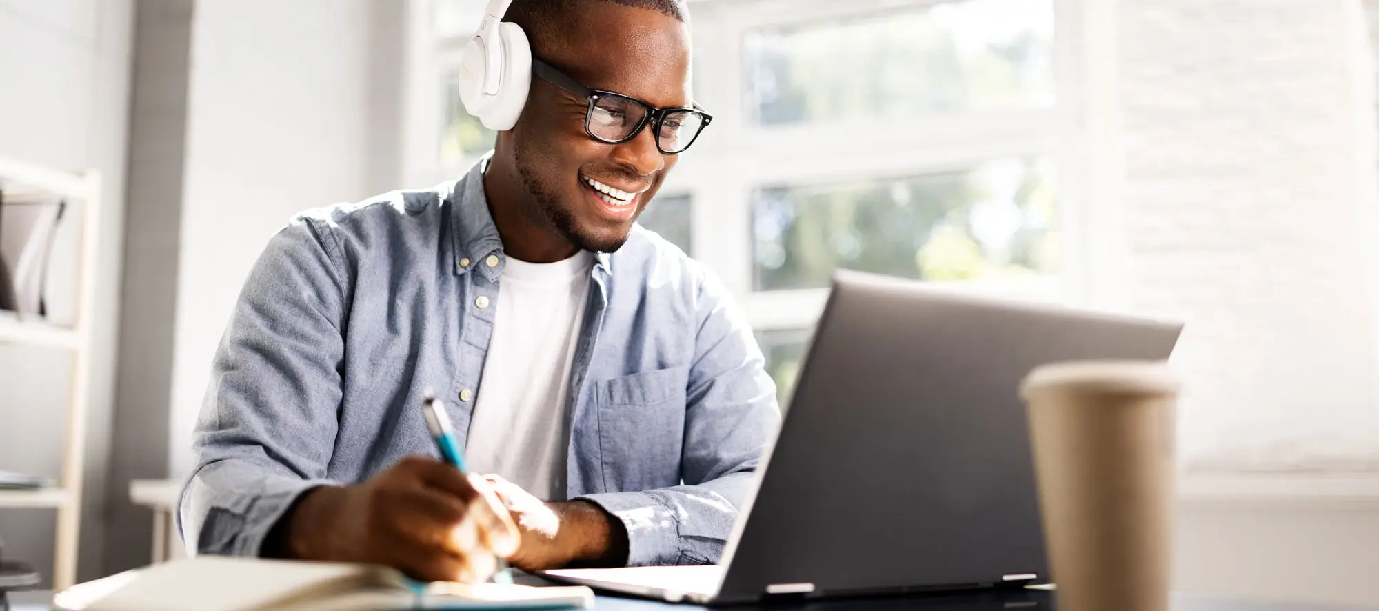 Man wearing headphones doing an online tutor session.
