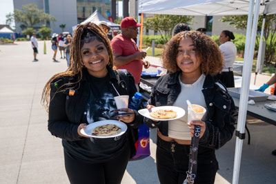 Two students carying food from the Fiesta event.