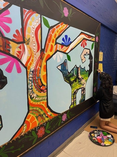 Painting a colorful mural on a large wall.