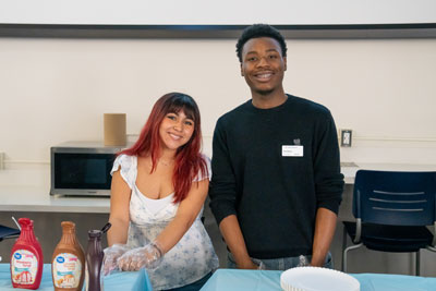 Peer mentors serving food at an event.